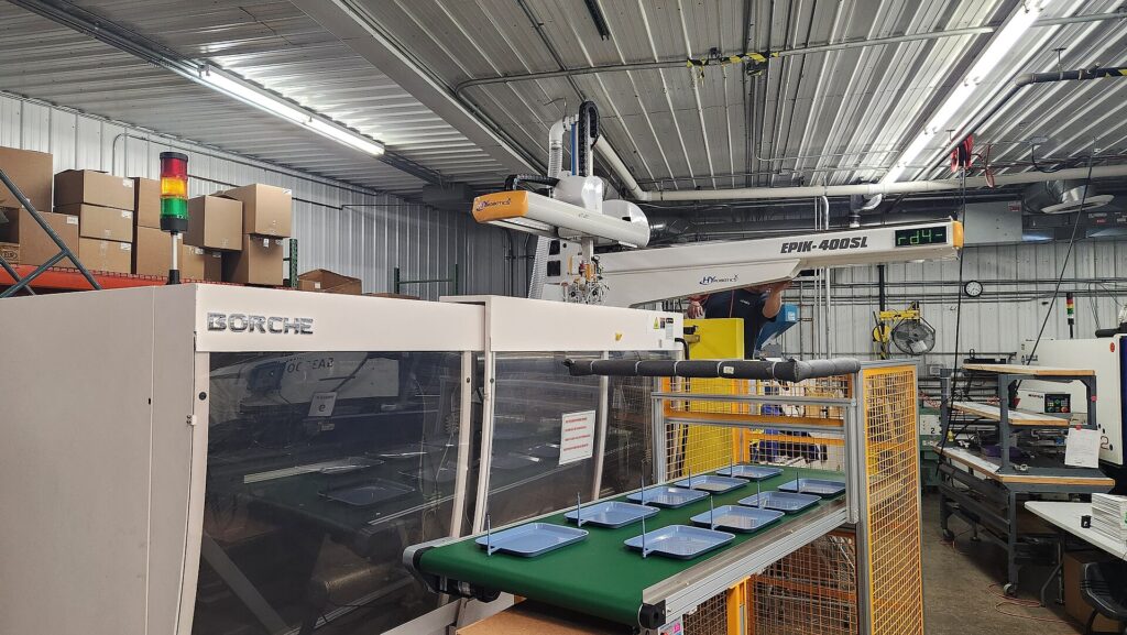 Máquina de inyección con brazo robotizado en planta
